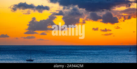 Golden sunset over the ocean with silhouetted sailboats in the water off Waikiki Beach; Honolulu, Oahu, Hawaii, USA Stock Photo