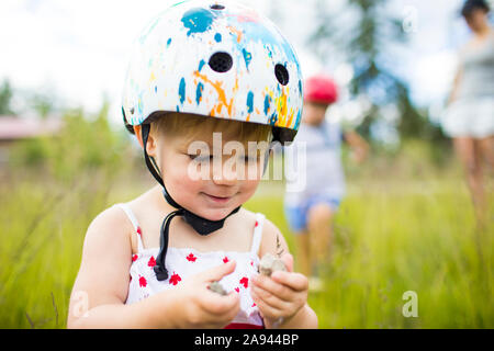 Young girl wearing helmet  enjoying time playing outside Stock Photo