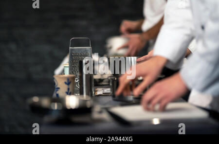 Team of professional chefs preparing food in a commercial kitchen. Cooks in the production process of system catering. An inside view of a pro caterin Stock Photo