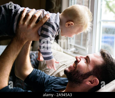 A father holds up his baby boy. Stock Photo