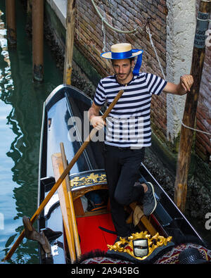 Venice, Italy - July 18th 2019: A portrait of a Gondolier in the city of Venice in Italy. Stock Photo