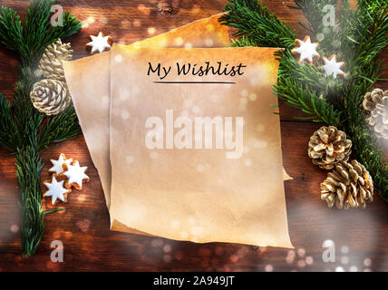Paper sheet with text My Wishlist between fir branches, cinnamon stars and Christmas decoration on rustic dark wood, wish list or letter to Santa Clau Stock Photo