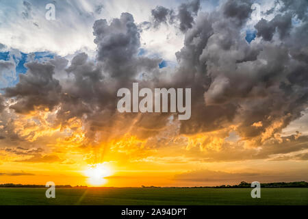 Bright golden sunset over the flat prairie land; Val Marie, Saskatchewan, Canada Stock Photo