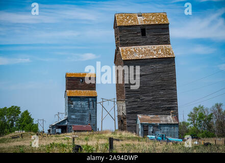 Two weathered grain elevators on the prairies; Val Marie, Saskatchewan, Canada Stock Photo