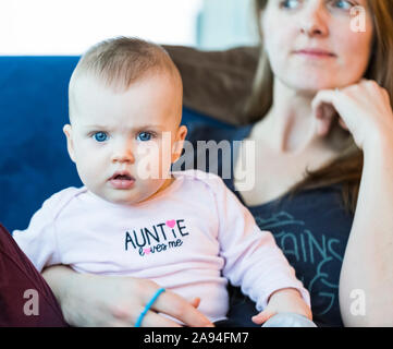 Portrait of infant baby girl with mother at home; Vancouver, British Columbia, Canada