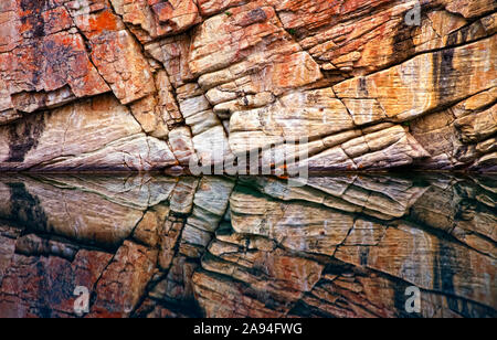Rock wall surface reflected in tranquil water of Horseshoe Lake, Jasper National Park; Alberta, Canada Stock Photo