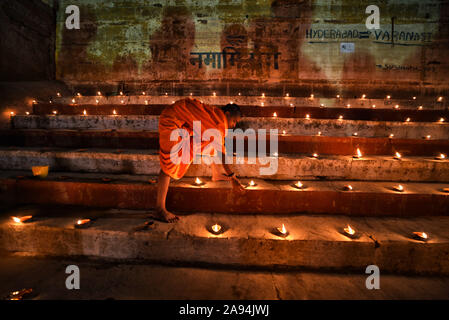 Varanasi, India. 12th Nov, 2019. An Indian Monk lights the Lamps on the eve of Dev Deepavali in Varanasi.Dev Deepavali is the biggest Light Festival of India where devotees decorate the river bank of Ganges with millions of Lamps as part of the festival. Credit: SOPA Images Limited/Alamy Live News Stock Photo