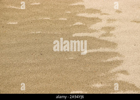 Wet and dry sand. The texture of yellow sand. Natural background. Stock Photo