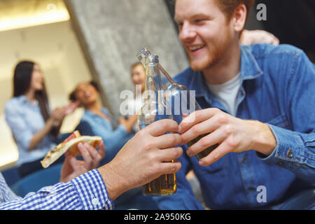 Group of friends having party indoors fun together drinking beer cheers close-up Stock Photo