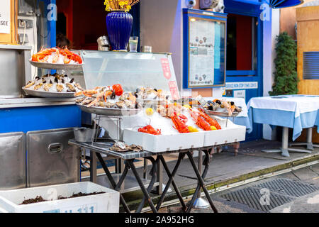 A sidewalk cafe on the Cours Saleya market in Nice, France, displays it's fresh seafood including lobsters in front of the store. Stock Photo