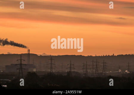 Wimbledon London, UK. 13 November, 2019. Electricity towers and power station are silhouetted during a colourful sunrise seen over Wimbledon SW London on a bright and cold autumnal morning . Credit: amer ghazzal/Alamy Live News Stock Photo