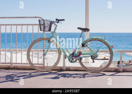 Nice, France, September 29, 2018: Urban ladies bicycle with a basket tied to a pole on a city street - urban ecological transport Stock Photo