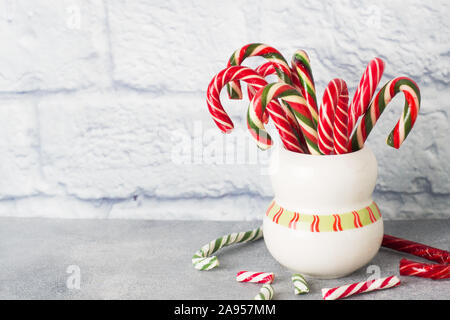 Christmas candy canes in cup on white background Stock Photo - Alamy