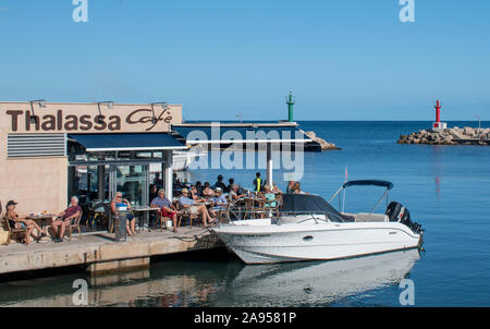 Cala Bona, Majorca, Spain, October 15, 2019, View of the marina in Majorca with tourists relaxing on the waters edge at the Thalassa Cafe Stock Photo