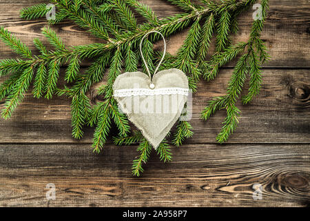 Textile decorative pillows in shape heart hanging on christmas tree branch Stock Photo