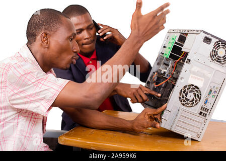 Young technicians sitting and working on broken computer at office Stock Photo