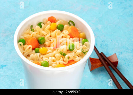 Ramen cup close-up, instant soba noodles in a plastic cup with vegetables, with chopsticks Stock Photo