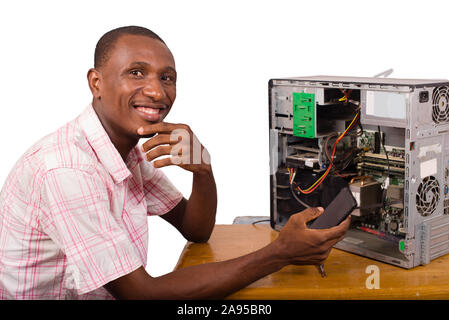 young smiling african worker in service repairing a computer and holding a mobile phone Stock Photo
