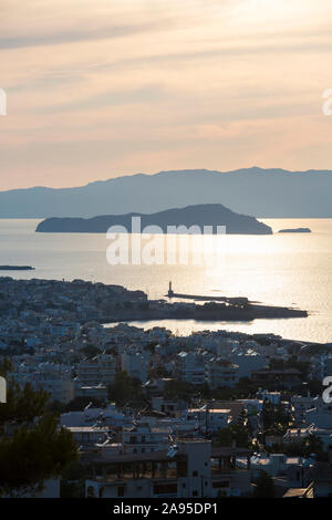 Chania, Crete, Greece. Backlit view over the city and Gulf of Chania, evening, the island of Agii Theodori prominent.