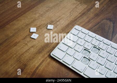 Broken keyboard on wooden desk Stock Photo