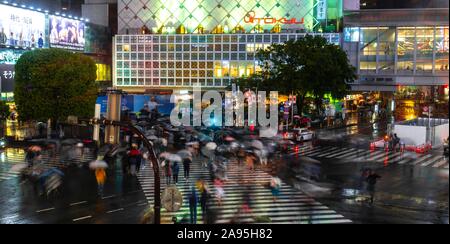 Crowd with umbrellas on zebra crossings at night, crossing Shibuya Crossing, Shibuya, Tokyo, Japan Stock Photo