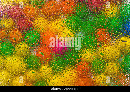 Abstract colorful background with drops of water on multicolor glass. The circles of color of rainbow on wet glass. Creative design. Stock Photo
