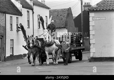 Dray horses 1980s Southwold Suffolk East Angelia. Men finished delivering crates barrels of beer, lorry with just wooden pallets. 1985 Men painting the building behind. UK HOMER SYKES Stock Photo