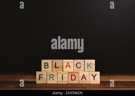 BLACK FRIDAY  word against black background on wooden table. Concept of online and digital shopping and marketing Stock Photo