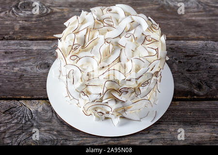 rustic style of a coconut cake decorated with coconut ribbons, close-up Stock Photo