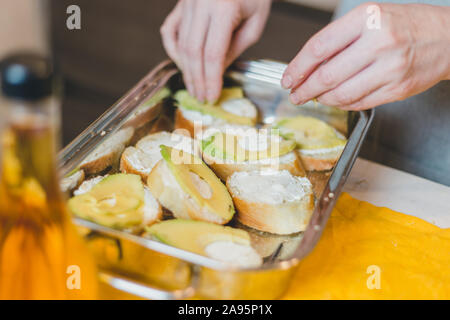Pumpkin sandwiches with white cream cheese and green avocado on a fresh baguette - home recipe for making bruschetta Stock Photo