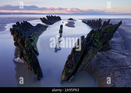 Shipwreck on Berrow beach in Burnham on Sea at low tide just after dawn on a clear crisp winter day. Stock Photo