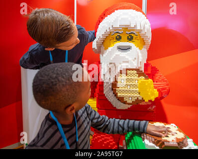 St Marys Church, Marylebone, London, UK. 13th November 2019. Dream Toys 2019 launch the top toys for Christmas, the most authoritative predictive list of what toys will be the hottest and most sought after this Christmas. (Children supplied with permissions by organisers). Image: Charlie and Mofe with Talking Lego Santa Claus. Credit: Malcolm Park/Alamy Live News. Stock Photo