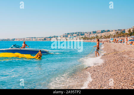 Nice, Provence / France - September 29, 2018: Tanned slim latin man throws a rope into the sea for a boat Stock Photo
