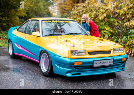 13 November 2019, North Rhine-Westphalia, Essen: Model Anja stands behind the Opel Manta, known from the action comedy 'Manta - the film' near the Schellenberg hunting lodge. The Essen Motor Show takes place this year from 30.11. to 08.12.. Photo: Marcel Kusch/dpa Stock Photo