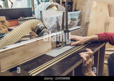 Carpentry workshop - preparation for the operation of the milling machine - setting the height of the cutter Stock Photo