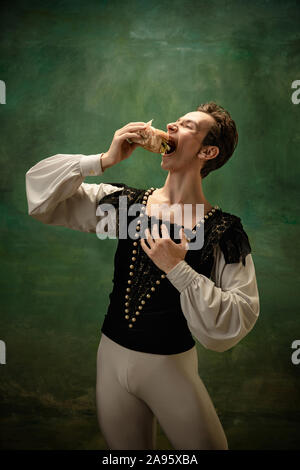Young ballet dancer as a Snow White's character with burger in forest. Flexible caucasian ballet artist like character of fairytail. Modern story in classic tales. Emotions, comparison of eras. Stock Photo