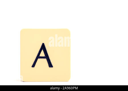 Dark letter A on a pale yellow square block isolated on white background Stock Photo