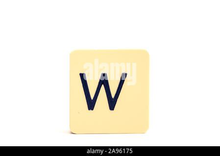 Dark letter W on a pale yellow square block isolated on white background Stock Photo