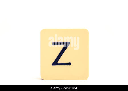 Dark letter Z on a pale yellow square block isolated on white background Stock Photo