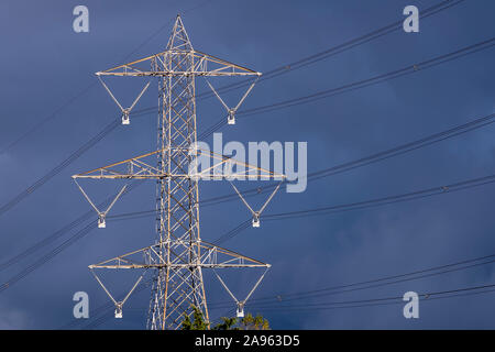 High voltage pylon isolated against a dark and stormy sky Stock Photo