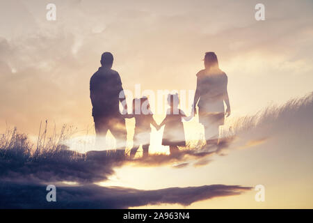 Happy family silhouette standing on against sunset time. Stock Photo