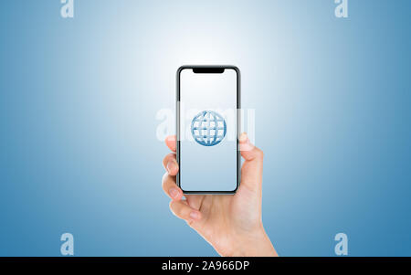 Male hand is holding and showing us a modern smart phone screen with Wireframe Globe symbol against blue background. Business, finance, technology and Stock Photo