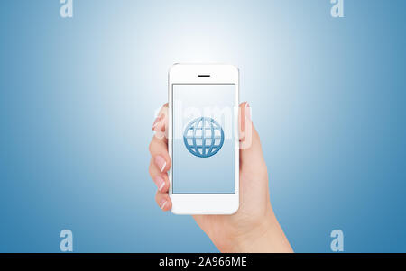 Female hand is holding and showing us a modern smart phone screen with Wireframe Globe symbol against blue background. Business, finance, technology a Stock Photo
