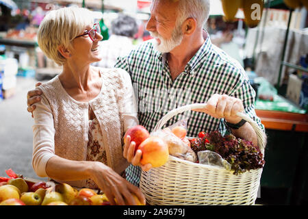 Mature couple shopping vegetables and fruits on the market. Healthy diet. Stock Photo