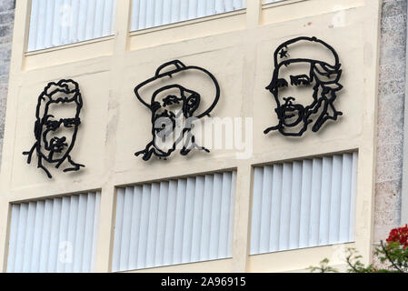 The three stylized portraits of three were heroes of the Cuban Revolution, Julio Antonio Mella, Camilo Cienfuegos and Che Guevara, high up on the wall Stock Photo