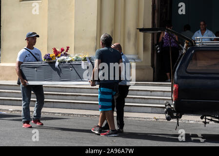 A funeral takes place as a cardboard coffin carried by friends and relatives,  is carried into the Capilla Central, located in the middle of Necropolis Stock Photo