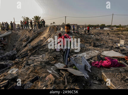 Gaza, Palestine. 13th Nov, 2019. A Palestinian boy carries belongings retrieved from a house destroyed in an Israeli air strike in the southern Gaza StripTension is rising in Gaza after the Al-Quds Brigades commander, the armed wing of Gaza based resistance faction Islamic Jihad, Bahaa Abu Al-Atta died in an Israeli airstrike. Credit: SOPA Images Limited/Alamy Live News Stock Photo