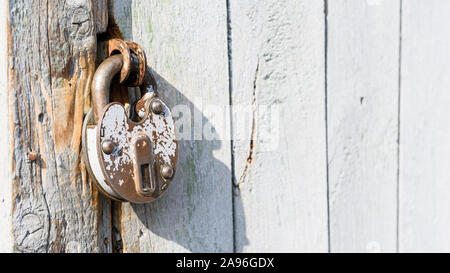 Antique padlock on a wooden door. Metal vintage lock. Rusty old door lock. Stock Photo