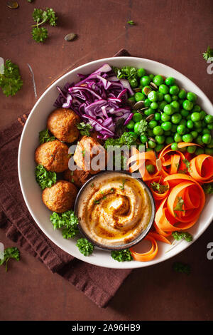 healthy vegan lunch bowl with falafel hummus carrot ribbons cabbage and peas Stock Photo