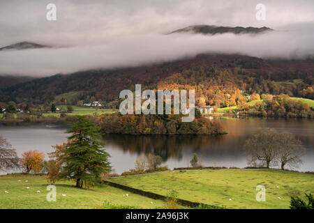 Low clouds and autumn mist hang over Grasmere (Rawnsleys) Island in the lake at Grasmere in the Lake District National Park Stock Photo